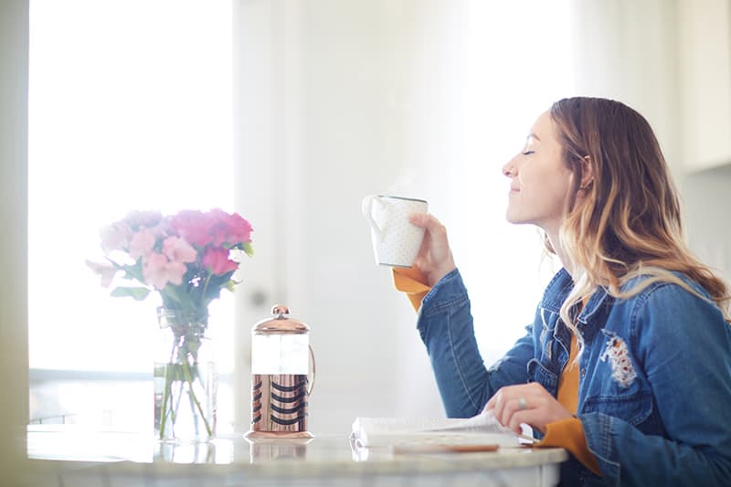 A Christian woman reading her Bible and enjoying her coffee after replacing grumbling with gratitude