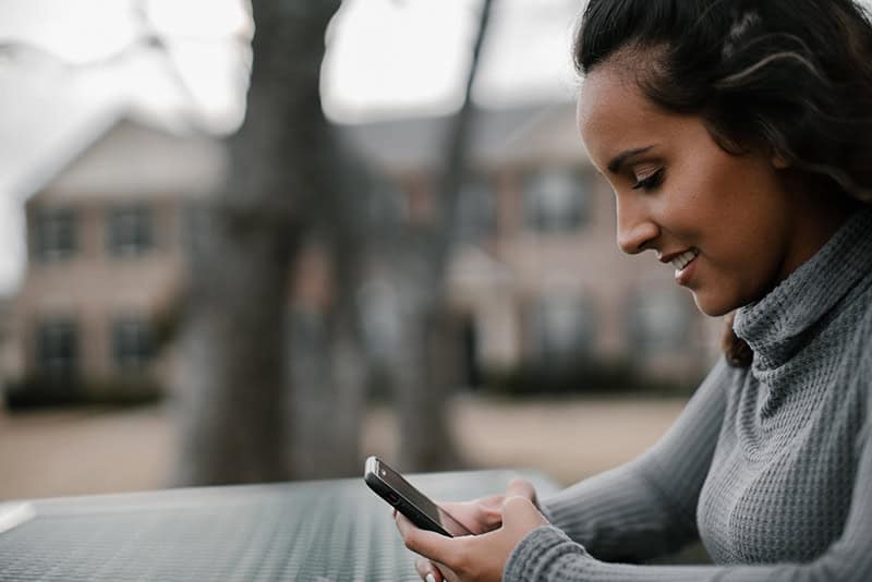 A Christian woman recording answers to prayer on her mobile phone to help her trust God in difficult seasons