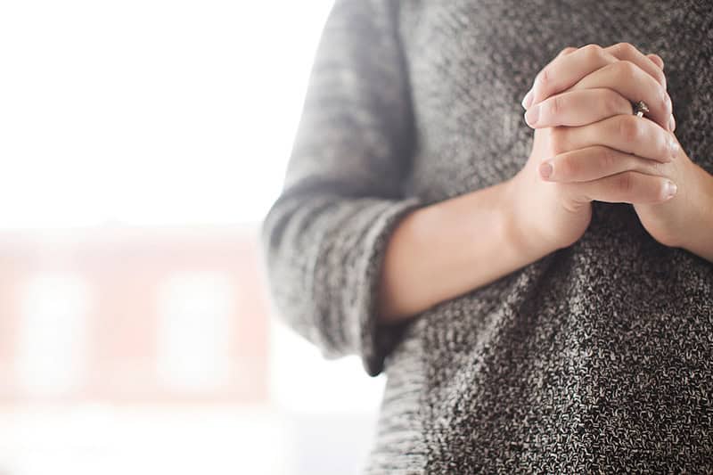 A Christian woman's hands folded in prayer