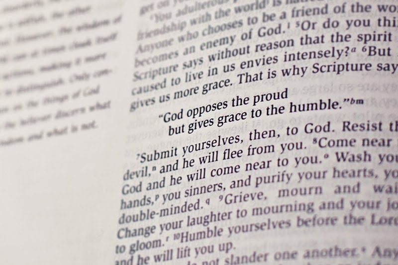 A Bible opened to a verse that says, "God opposes the proud but gives grace to the humble."
