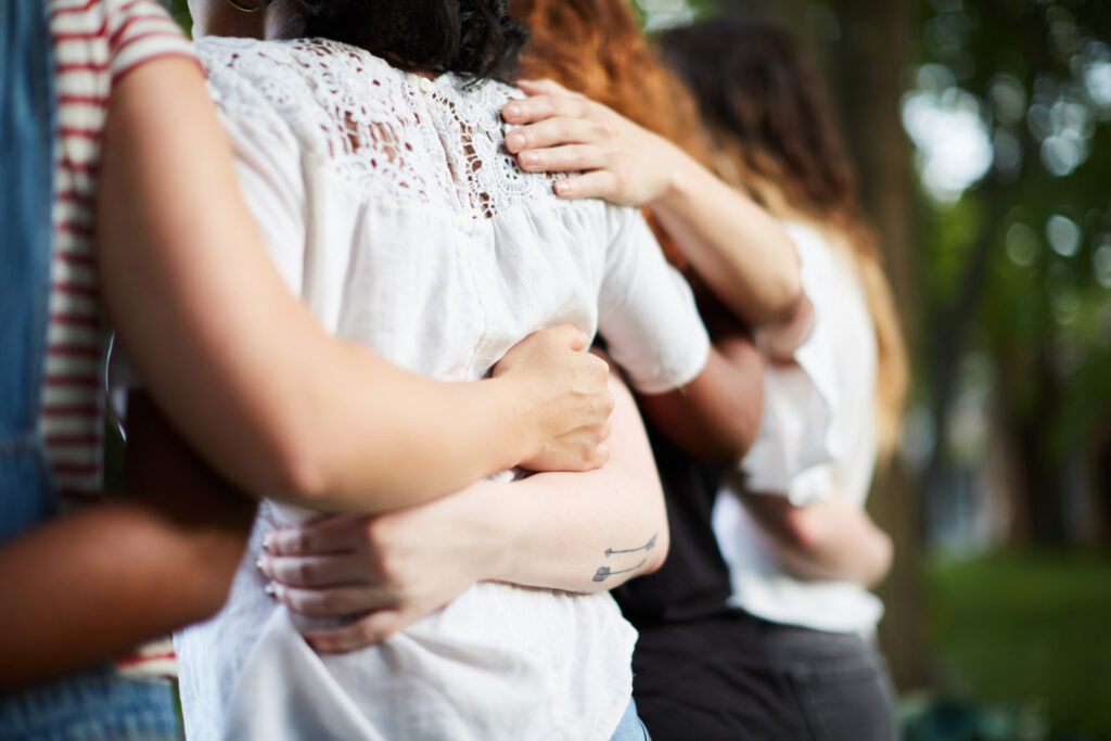 A group of Christian women engaged in a group hug as they live out what it means to be loved and fully known by God