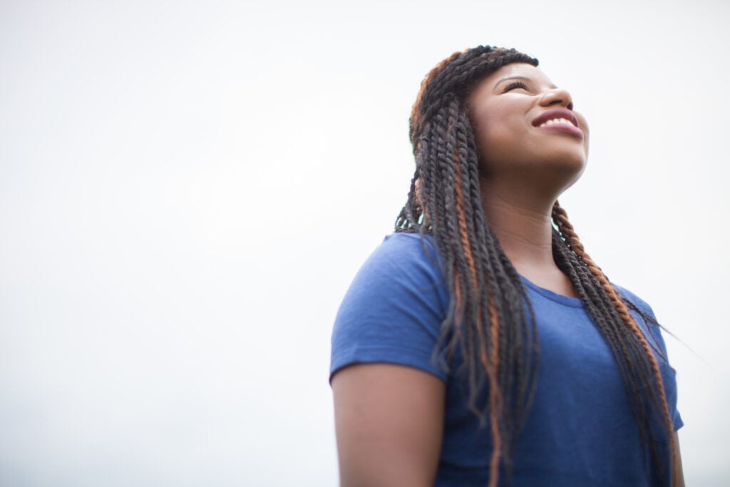 A Christian woman looking up as she tries to find joy in challenging times