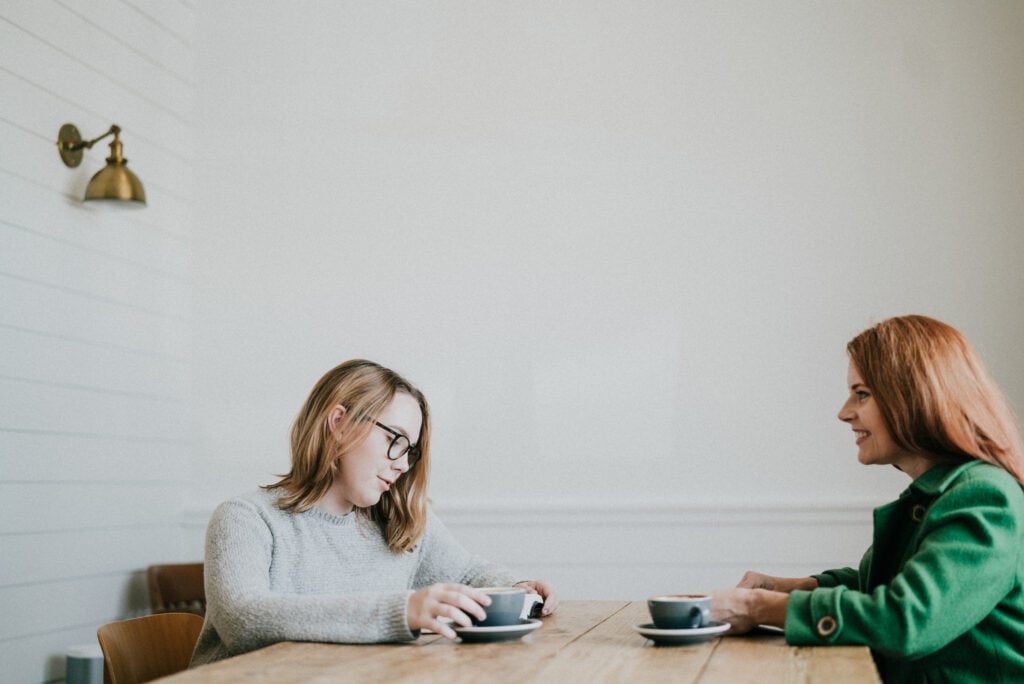 Steal Your Joy 3 Two Christian women sitting across from each other at a table with mugs of coffee, discussing lies that steal your joy