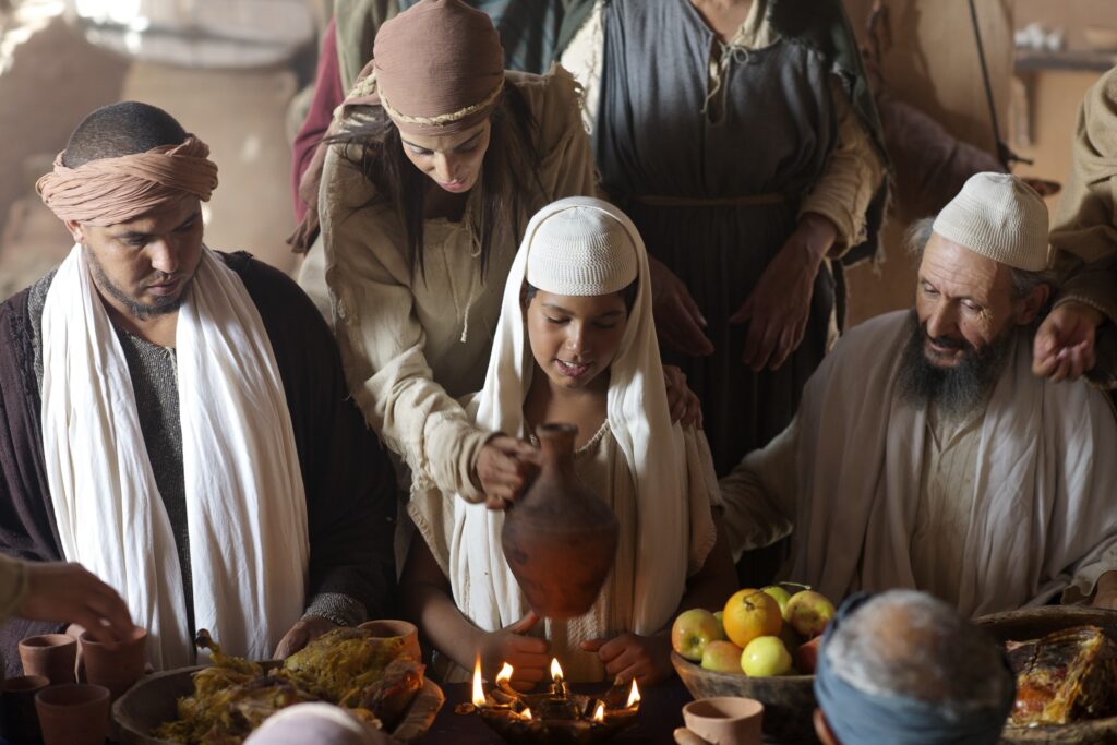 A group of people dressed in ancient biblical clothing gathered around a table for a feast