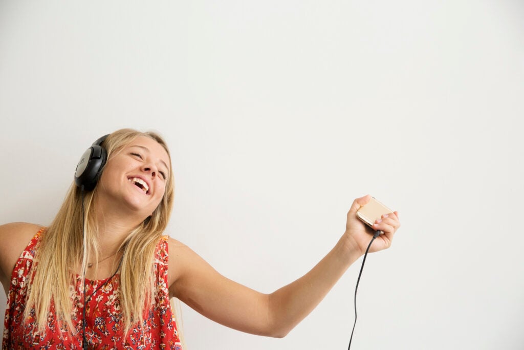 A Christian woman experiencing the power of praise as she dances to the music playing in her headphones