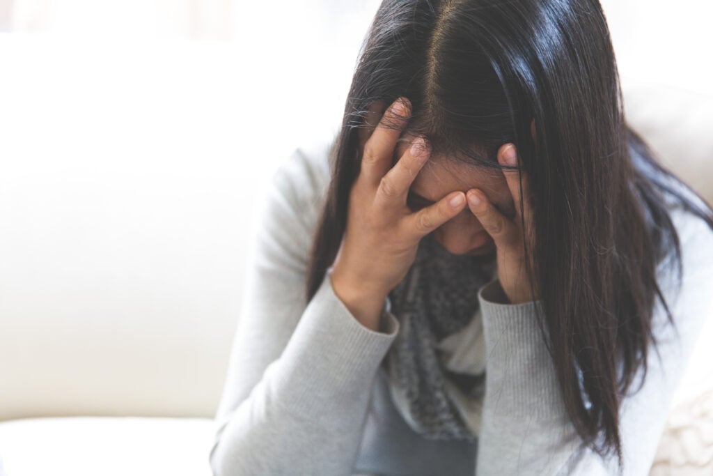 A Christian woman with her head in her hands
