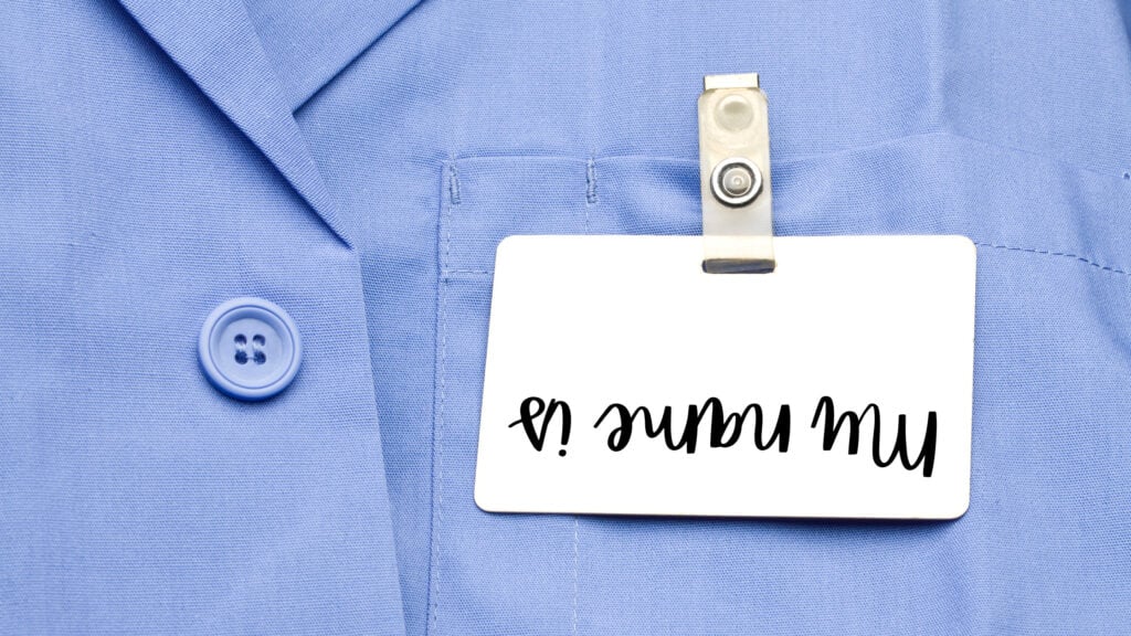 An upside down name tag, hanging on a blue shirt