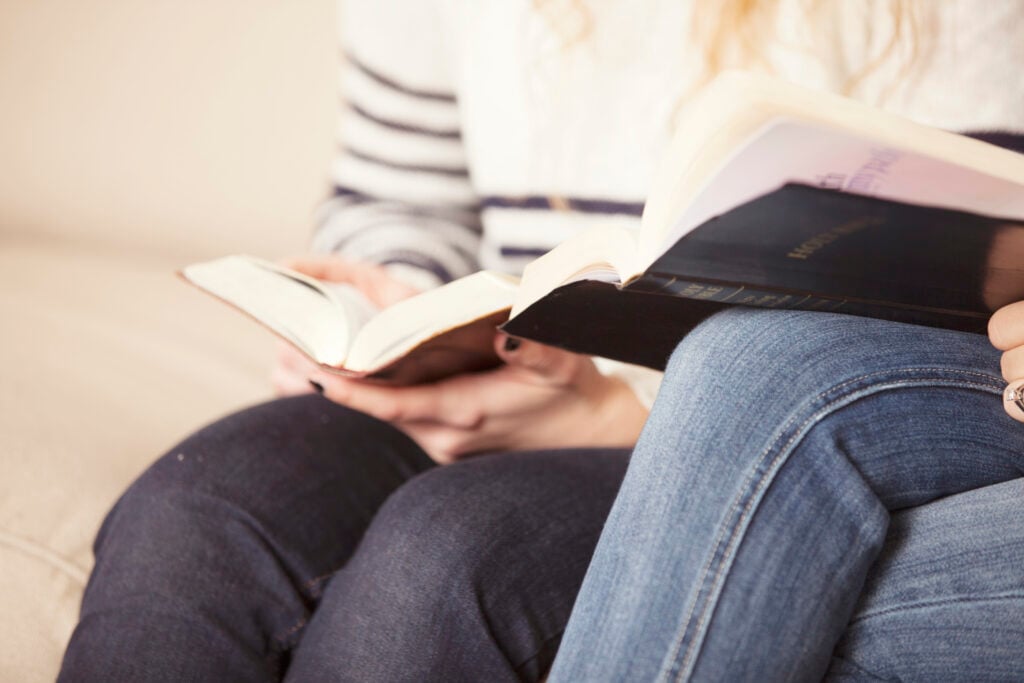 Two Christian women sitting side-by-side on a couch to study the Bible about speaking the truth in love