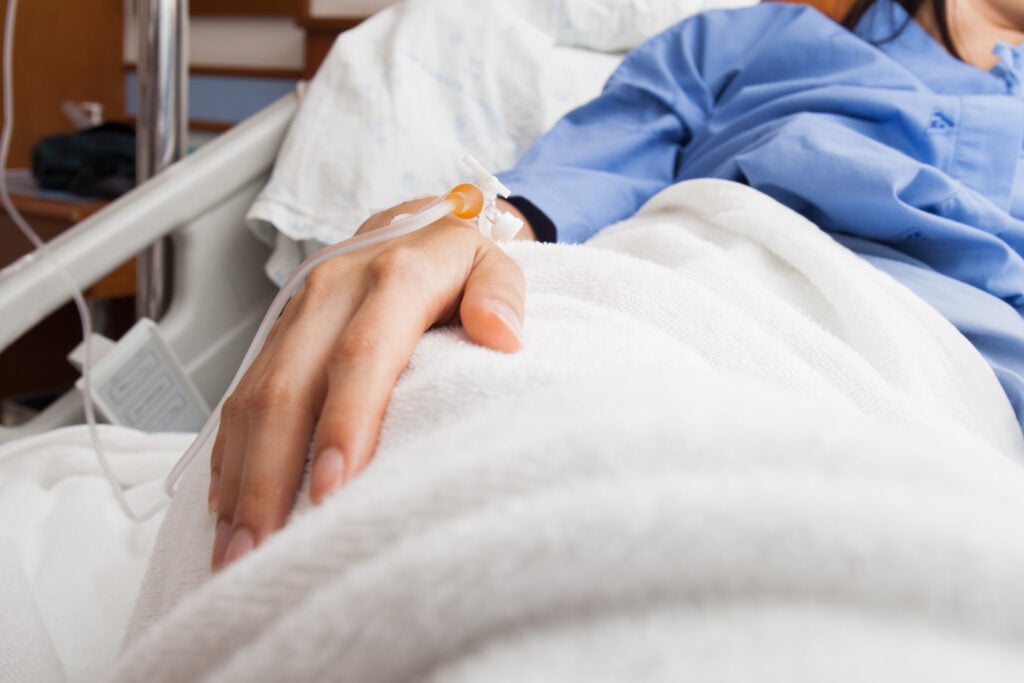 A Christian woman laying in a hospital bed, hooked up to an IV, wondering about the goodness of God in difficult times