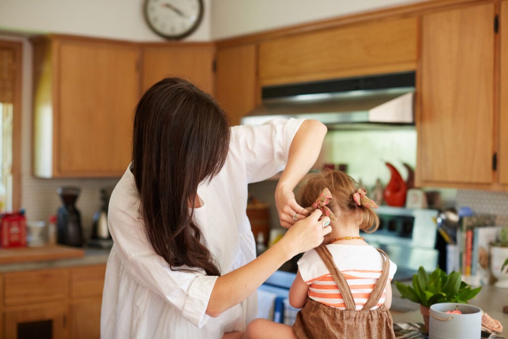 A Christian mom who knows her labor is not in vain as she fixes her toddler daughter's pigtails