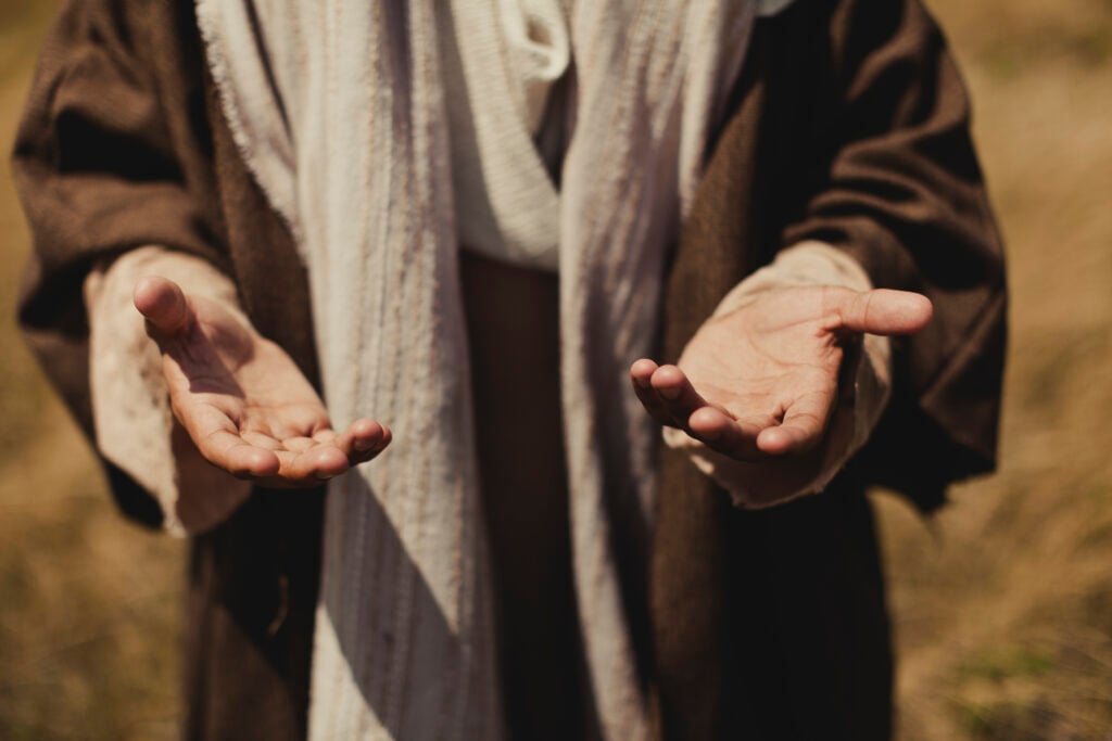 A man dressed in ancient Israelite garments—robes—with his palms held open in front of him, demonstrating his waiting on God's faithfulness